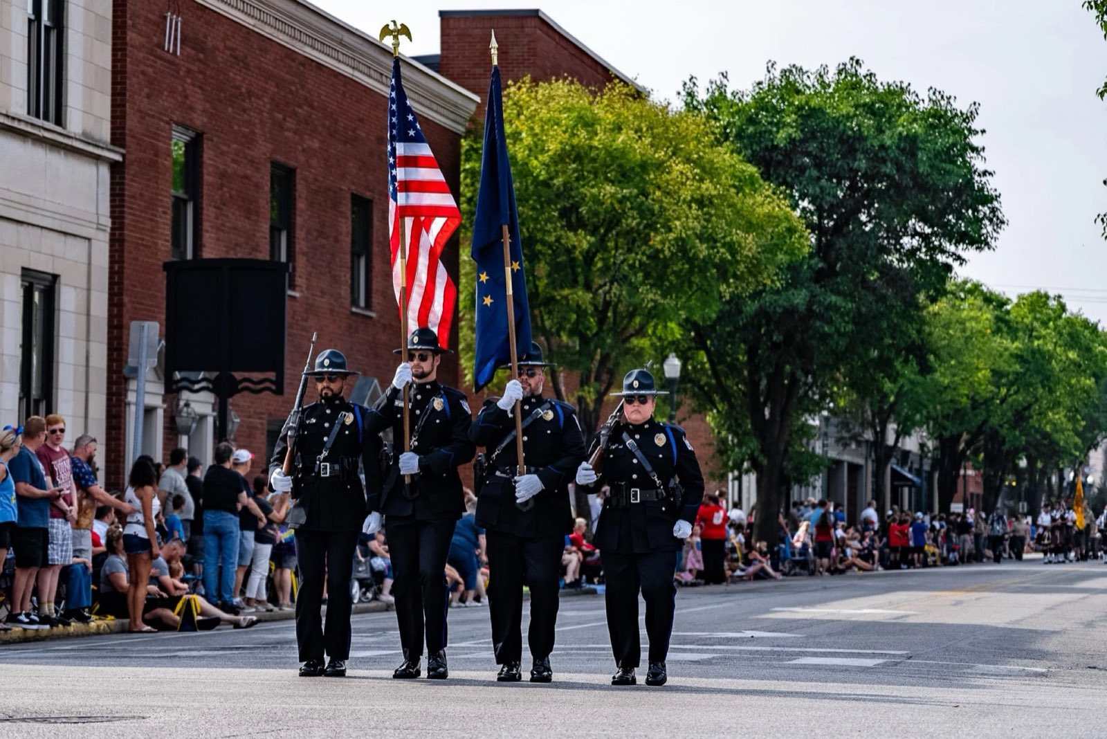 Jeffersonville Police honor guard carrying the American and Indiana flags down Spring Street during a parade